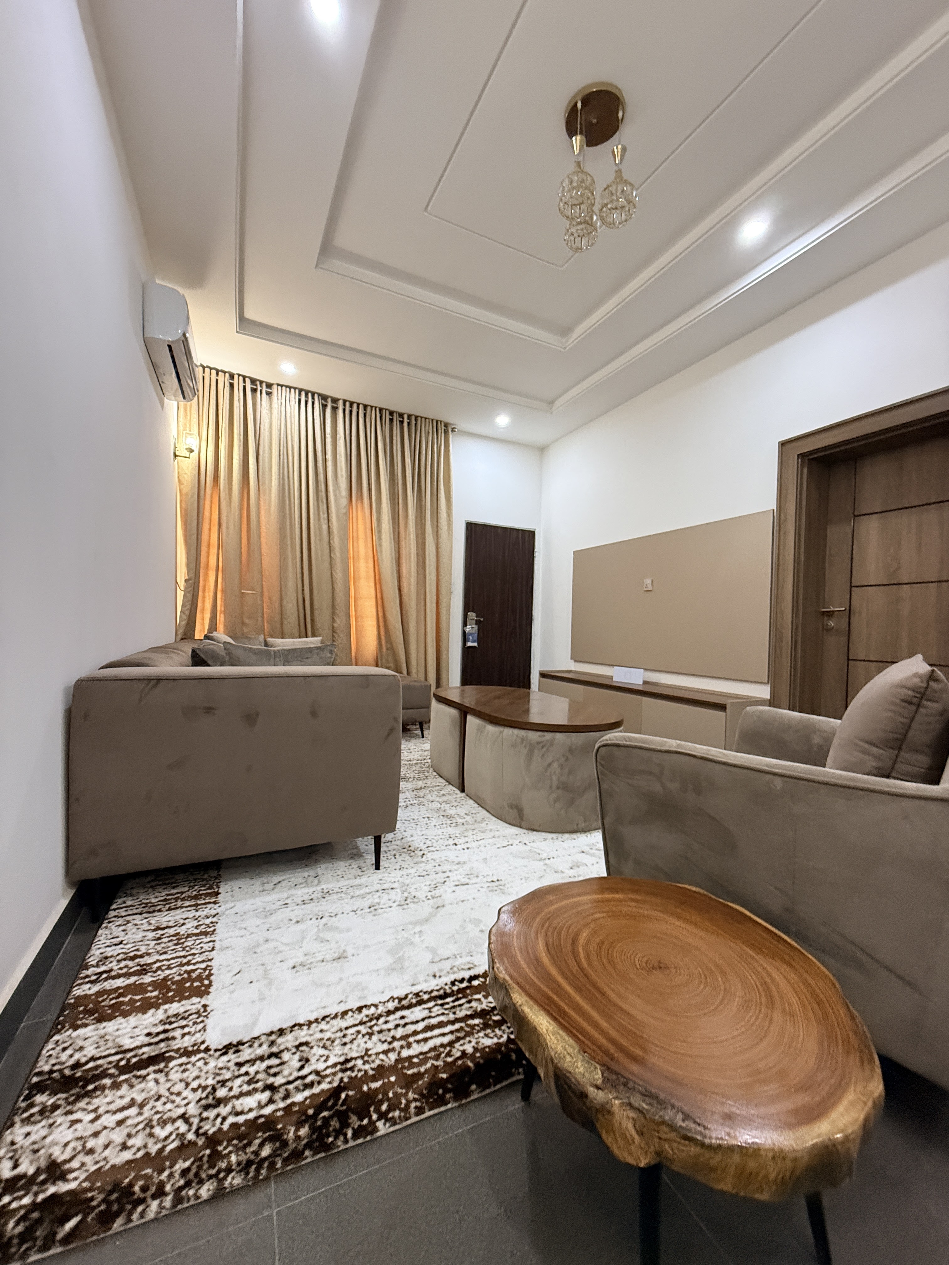 Compact lounge with warm curtains and wood table