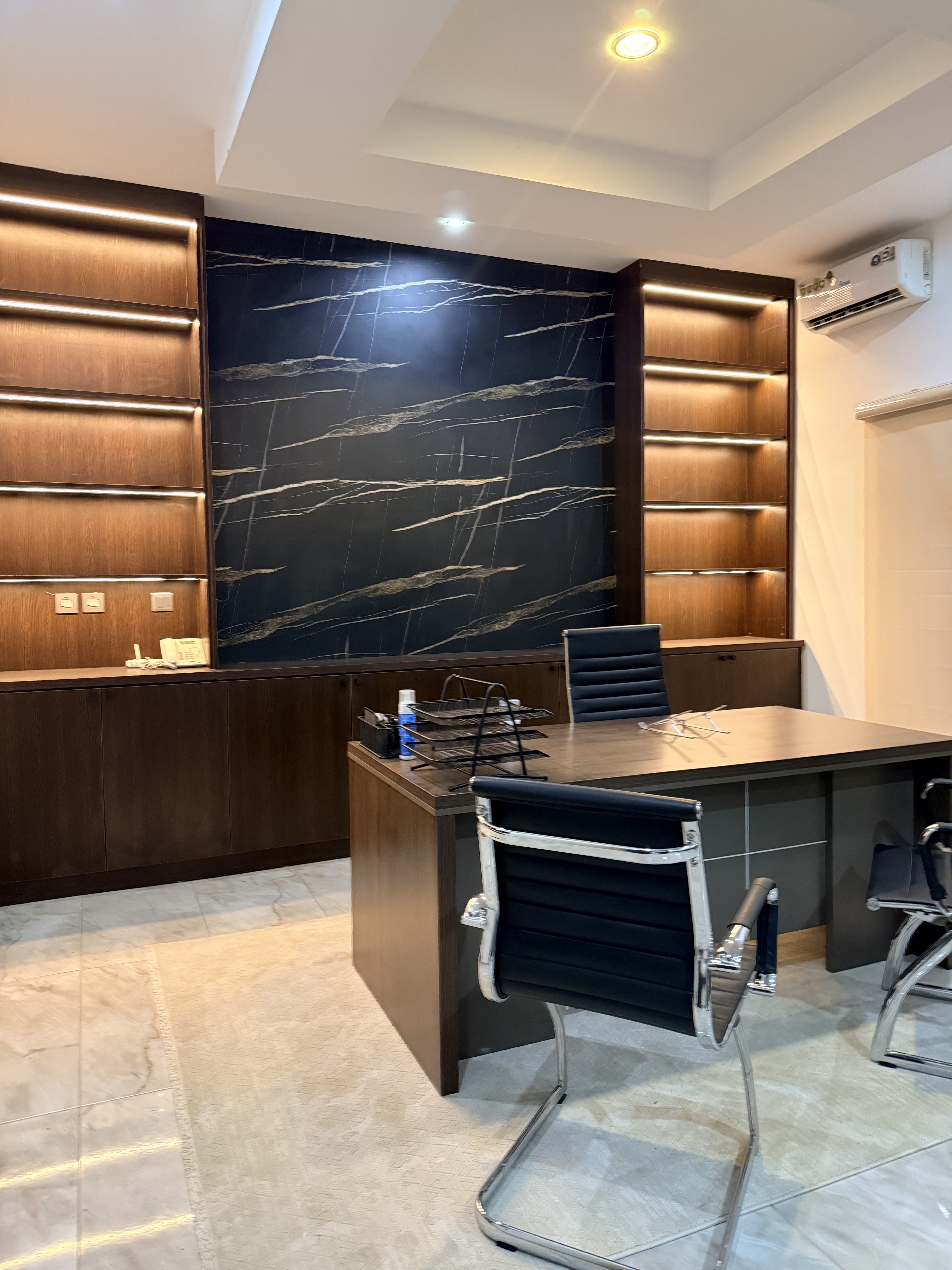 Executive office with marble wall panel and wood shelves